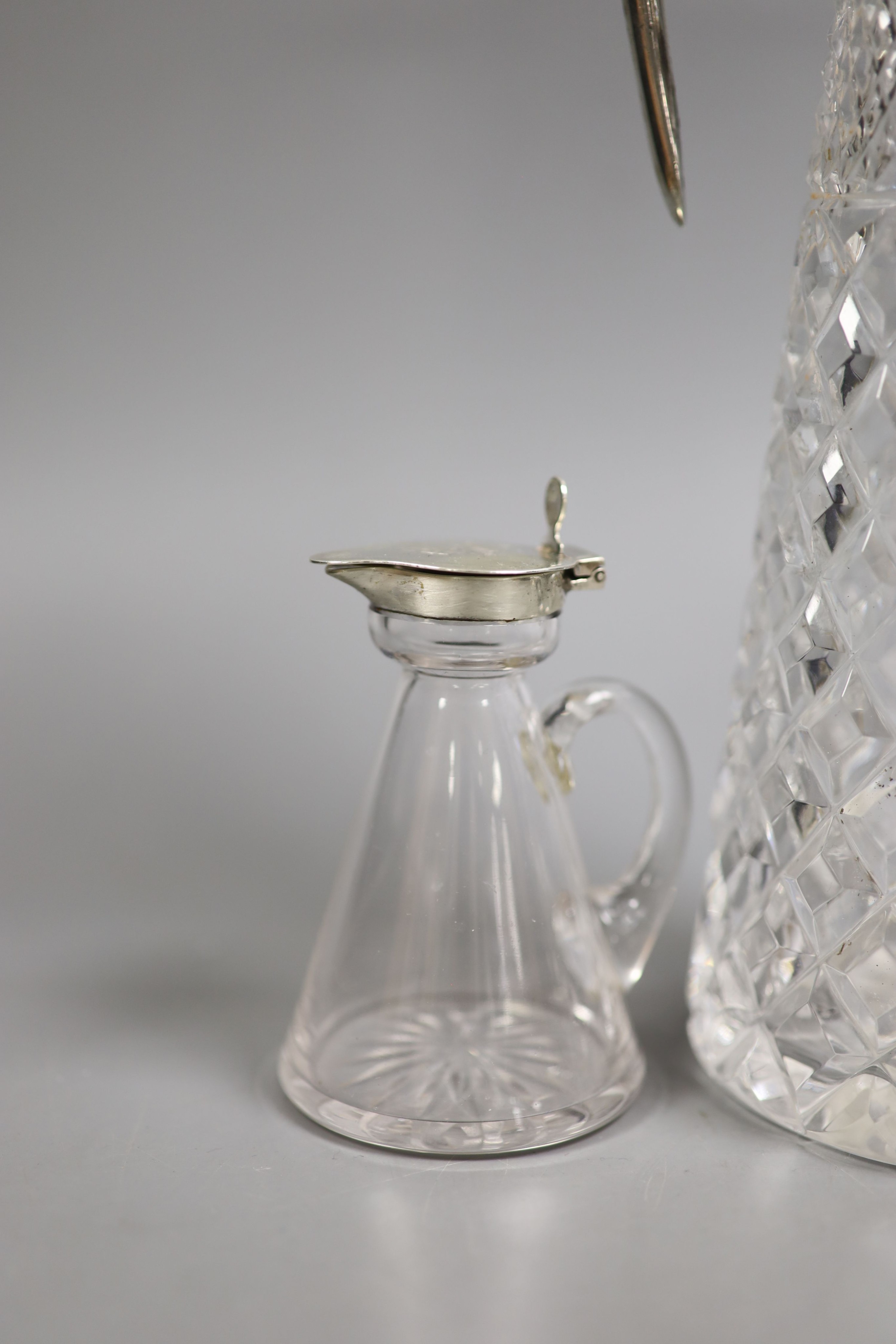 A late Victorian silver mounted cut glass claret jug, Atkin Bros. Sheffield, 1891, 29.4cm and a George V silver mounted glass whisky tot jug.